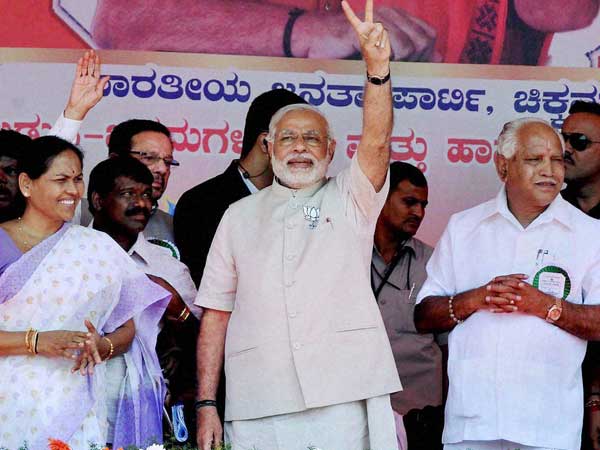 Narendra Modi flashes a victory sign at an election rally