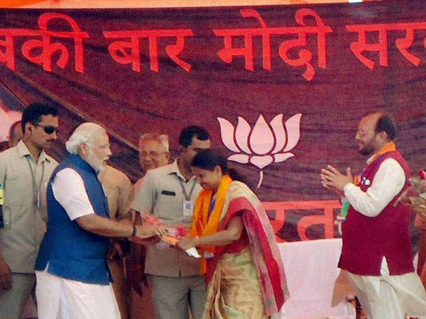 Narendra Modi is greeted at an election campaign rally