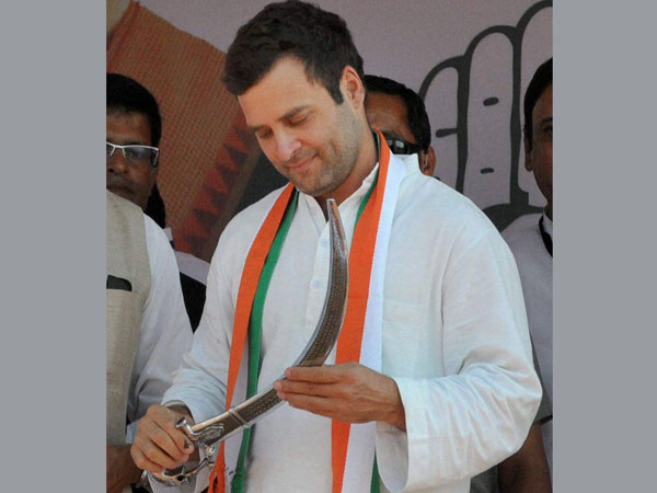 Rahul Gandhi holds a sword during an election rally