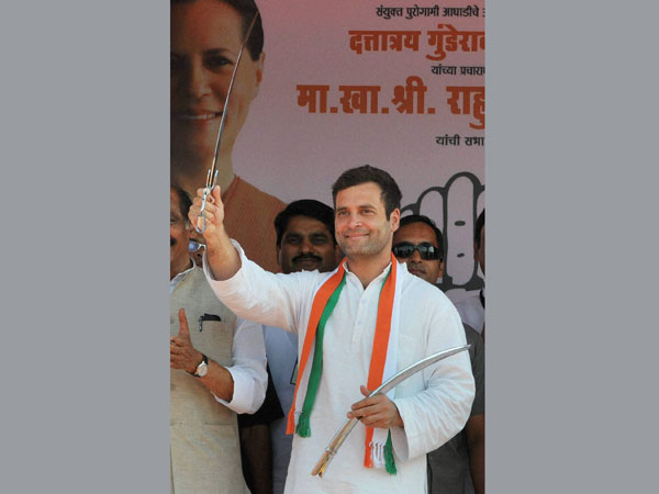 Rahul Gandhi holds a sword during an election rally