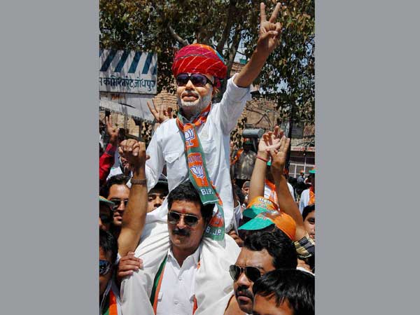 A supporter, wearing BJP prime minister candidate Narendra Modi's mask