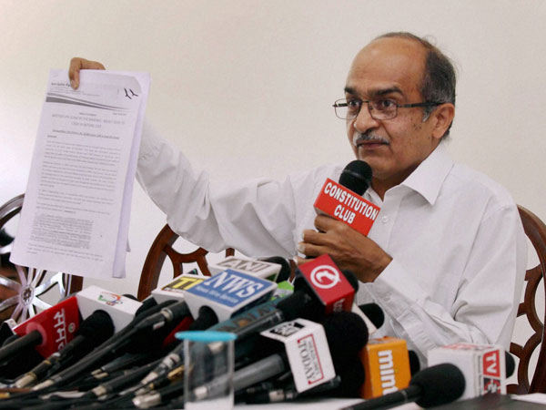 AAP leader Prashant Bhushan shows a document