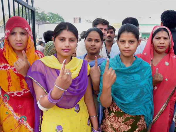Women voters show their inked fingers after casting votes 