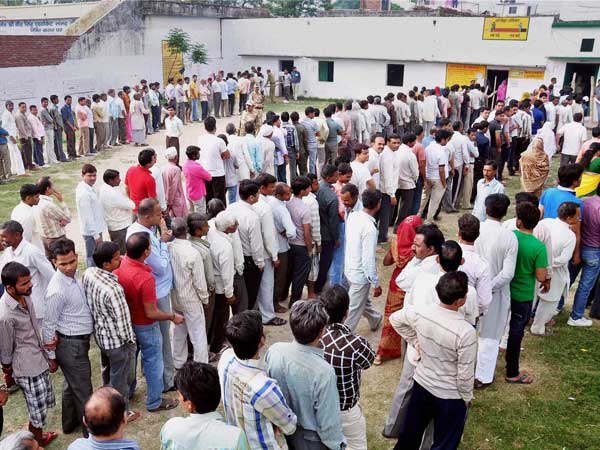 Voters stand in queue to cast their vote for Lok Sabha elections