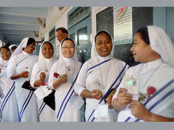 Catholic nuns wait in a queue to cast their votes