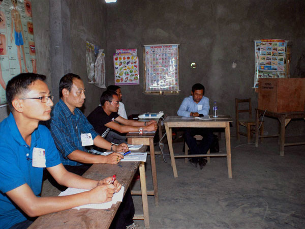 Polling officials sitting idle at a polling station as villagers 