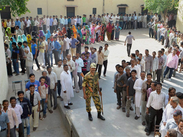 Voters wait in queues to cast their votes