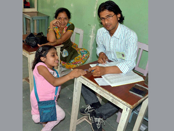 A dwarf girl before casting her vote
