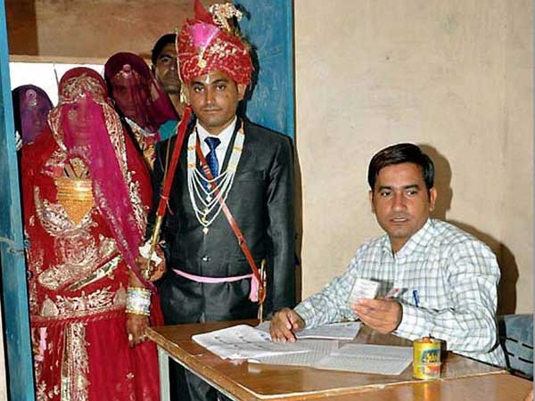 A newly wed couple arrives to cast votes