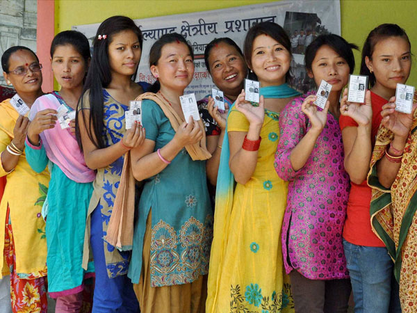 Voters stand in a queue to cast their votes