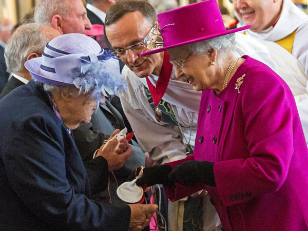 Britain's Queen Elizabeth II right, reacts with pensioner Mrs Bradshaw