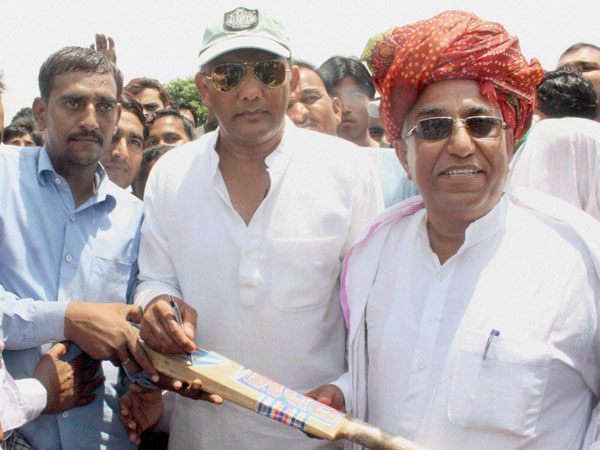 M Azharuddin gives autograph on bat during a public meeting in Tonk