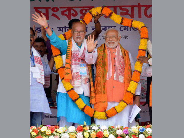 Narendra Modi is garlanded with party candidate Ramen Deka
