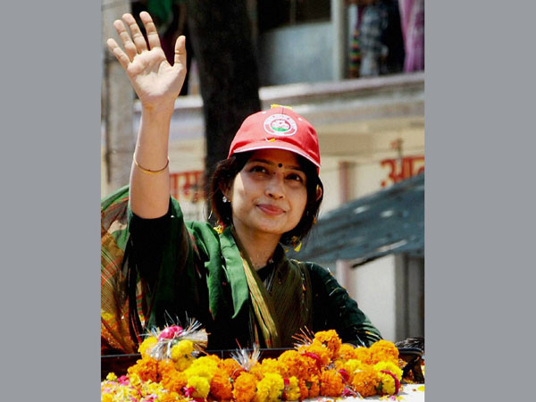 Dimple Yadav waves to the supporters during a roadshow