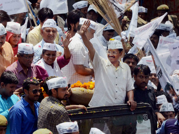 Arvind Kejariwal waves to supporters at a roadshow