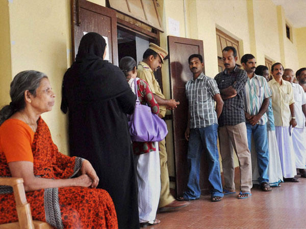 Voters stand in queue to cast their votes
