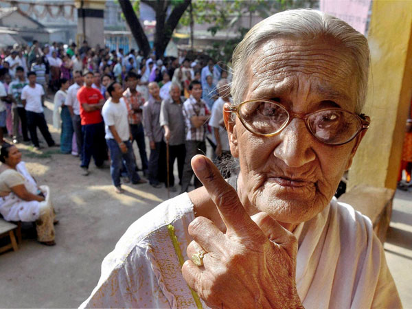 An old woman shows her inked finger