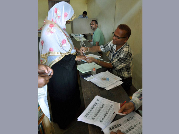 A polling officer applies ink on the finger
