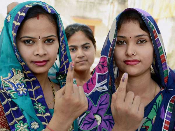 Women shows their inked fingers after casting their vote