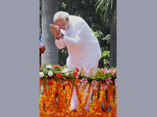 Narendra Modi greets supporters at a road show