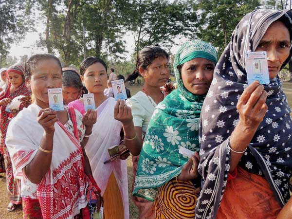 People wait in long queues to cast their votes