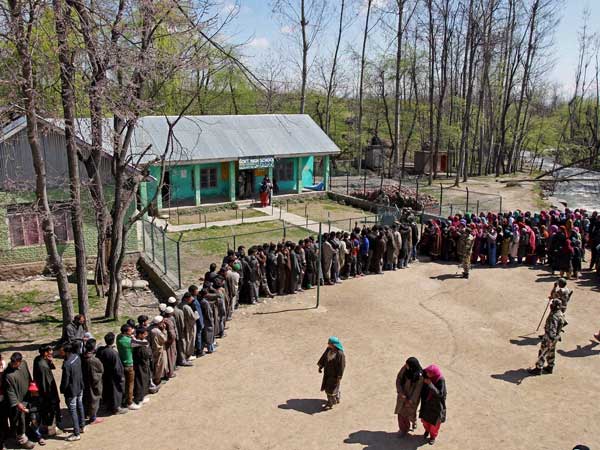 Voters wait in a long queue to cast their votes