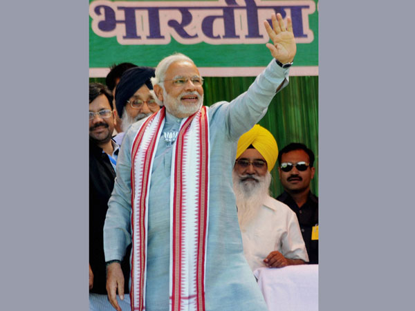 Narendra Modi waves at supporters during an election rally