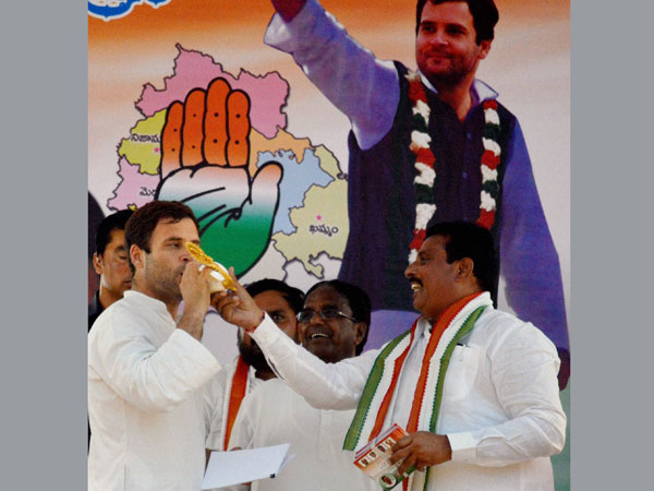 Rahul Gandhi blows a conch at a public meeting during an election campaign