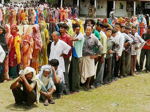 People stand in a queue to cast their vote