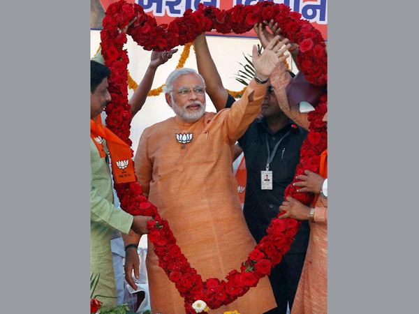 Narendra Modi is garlanded during an election campaign
