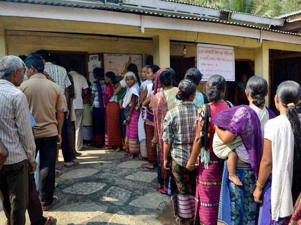 People stand in queue to cast their vote