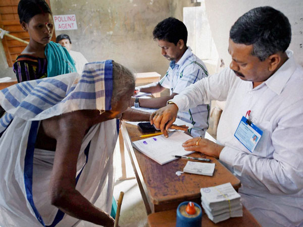 An elderly woman gives her thumb impression 