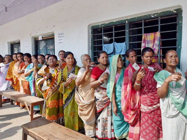 Women stand in a queue to cast their votes