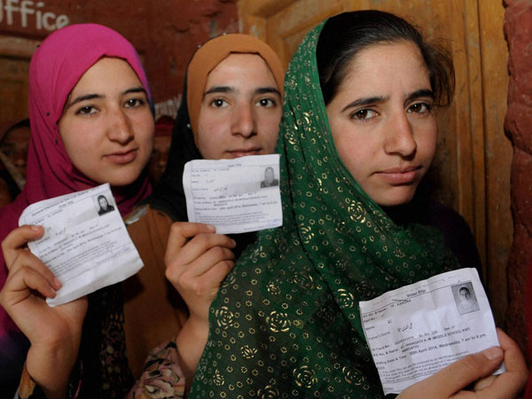 Kashmiri youngsters show their voter identity cards