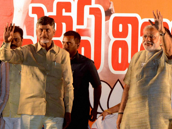 Narendra Modi and TDP President N. Chandrababu Naidu wave to the crowd