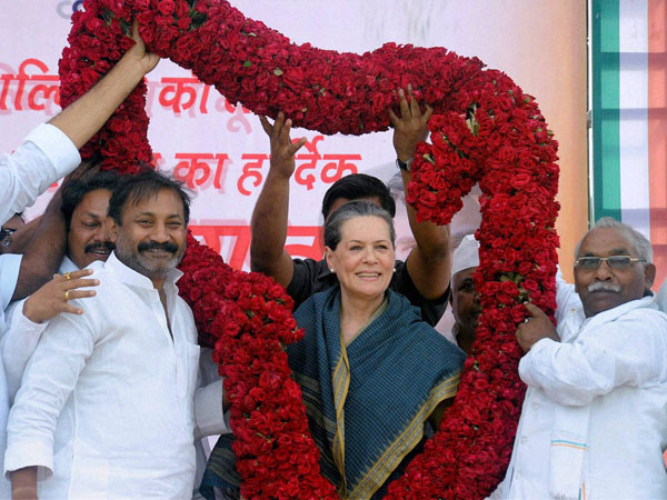 Sonia Gandhi is garlanded by supporters during an election campaign