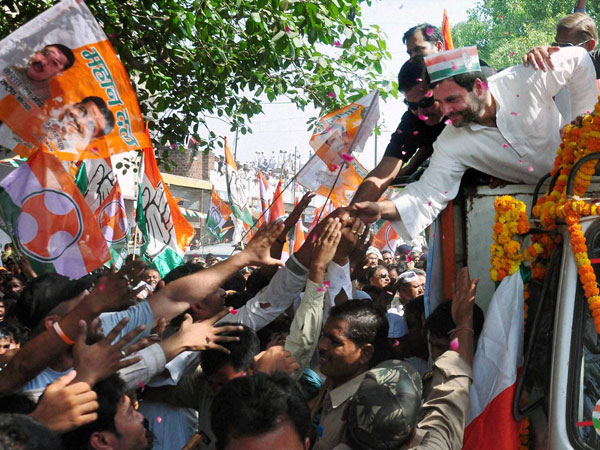 Rahul Gandhi shakes hands with supporters during an election road show 