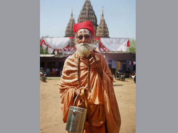 A Sadhu shows his inked finger after casting his vote