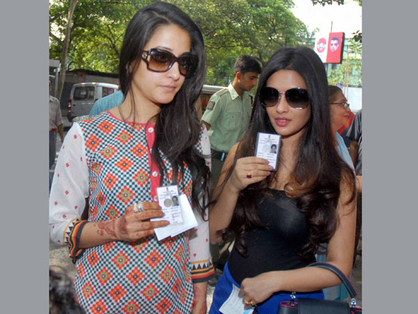 Bollywood actresses Raima Sen and Riya Sen (R) arrive at a polling station