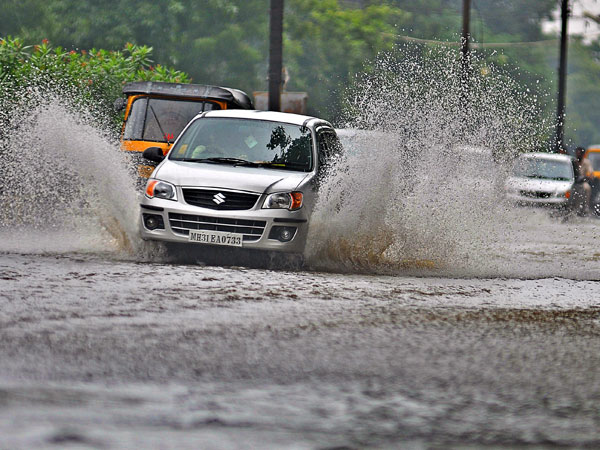 A car passes through a flooded street after unexpected rains