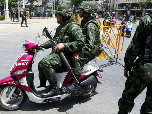 Armed Thai soldiers patrol on a motorbike