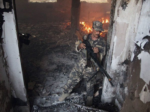 An Afghan soldier takes position at the site of a clash 