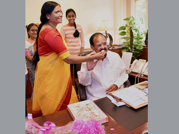 M Venkaiah Naidu being offered sweets by his wife M. Ushamma