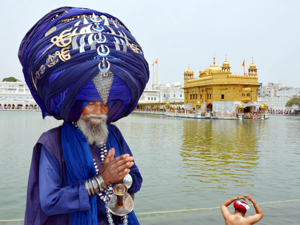 A Sikh Nihang wearing a huge turban pays obeisance at Golden Temple