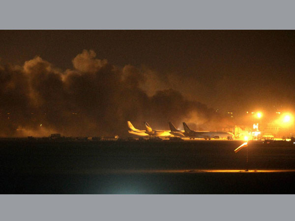 Fire illuminates the sky above Karachi airport terminal where security forces are fighting with attackers Sunday night, June 8, 2014, in Pakistan. Gunmen disguised as police guards attacked the terminal with machine guns and a rocket launcher during a five-hour siege that killed 13 people as explosions echoed into the night, while security forces retaliated and killed all the attackers, officials said Monday.