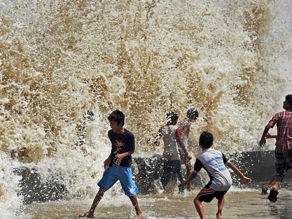 Children enjoy a high tide at Worli seaface in Mumbai