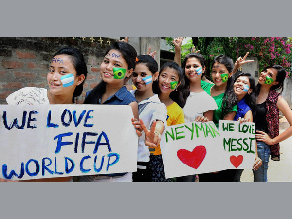 Girls hold placards and paint their faces with flags