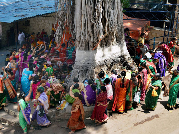 Married women tie threads around a Banyan tree