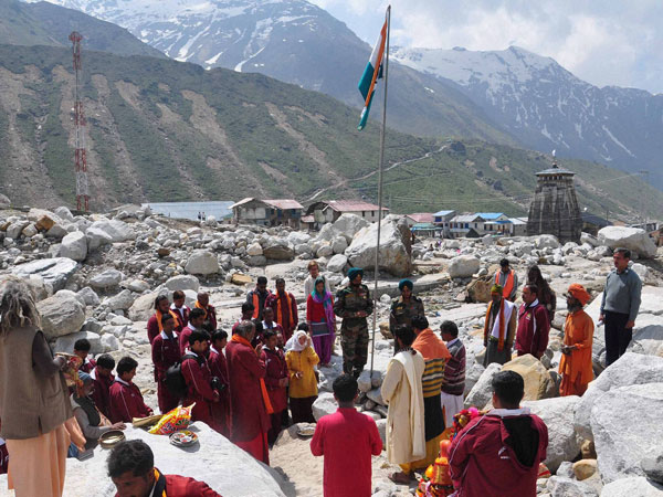 Army officers and devotees stand for national anthem