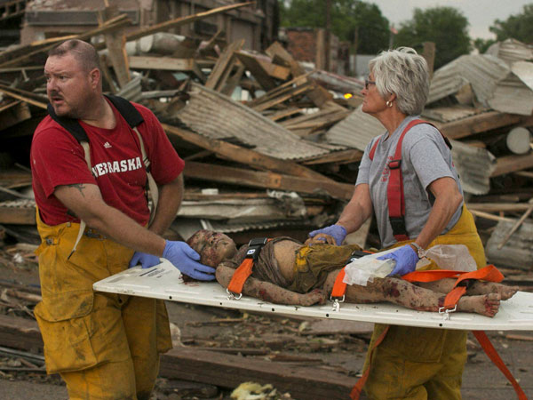 Rescue personnel tend to a young tornado victim